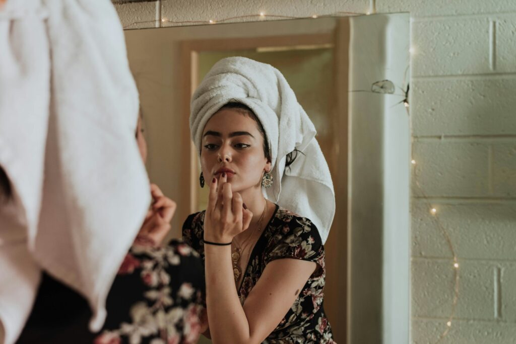 Woman looking at her lips in a mirror after a filler appointment