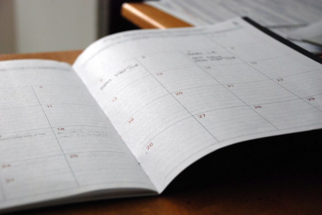 Calendar and notebook used to plan an appointment ahead of an event | LightTouch Med Spa Calendar and notebook used to plan an appointment ahead of an event