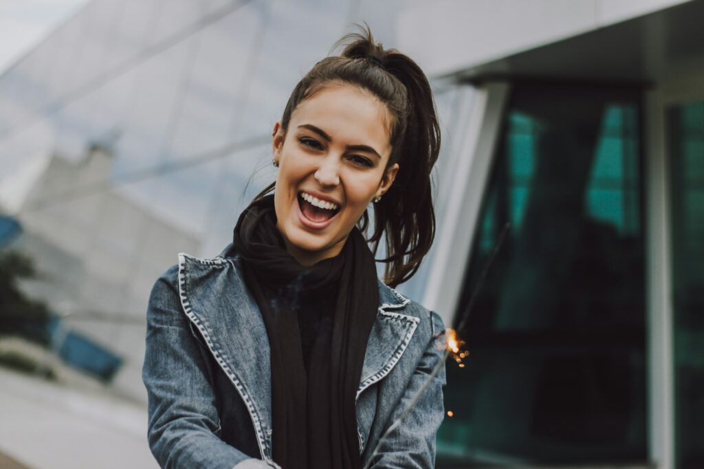 Smiling woman outdoors with natural expression lines around her eyes | LightTouch Med Spa Smiling woman outdoors with natural expression lines around her eyes